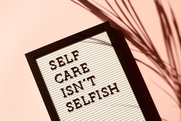 Sign: "Self Care Isn't Selfish" when living your life to the fullest