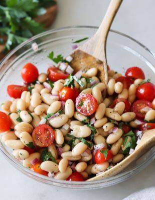 A glass bowl full of Cannellini Bean Salad