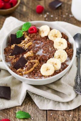 A breakfast bowl filled with quinoa, bananas, and chocolate