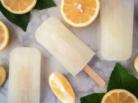 Lemonade popsicles with lemon slices on a counter