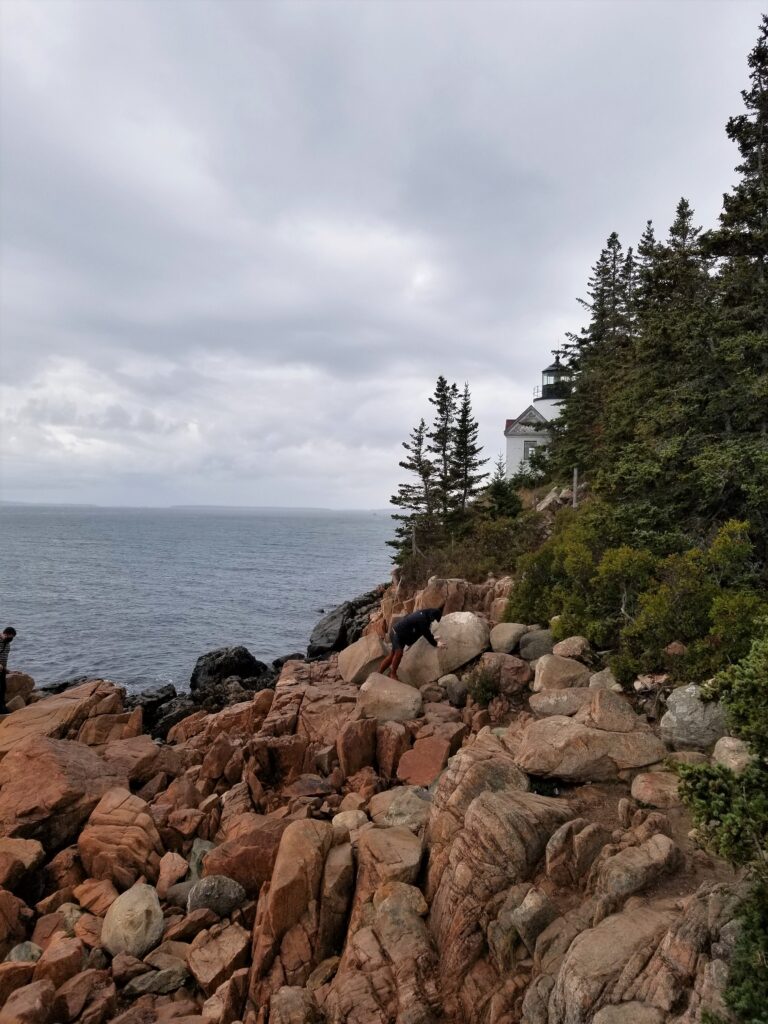 Rocky shoreline of Acadia National Park with Schoodic Head LIghthouse in the background