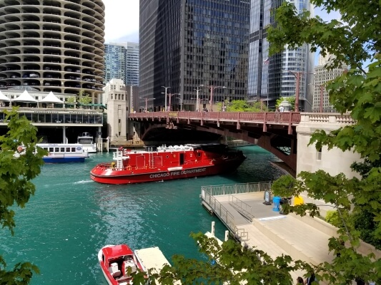 Fire boat on the Chicago River with skyscrapers in the background